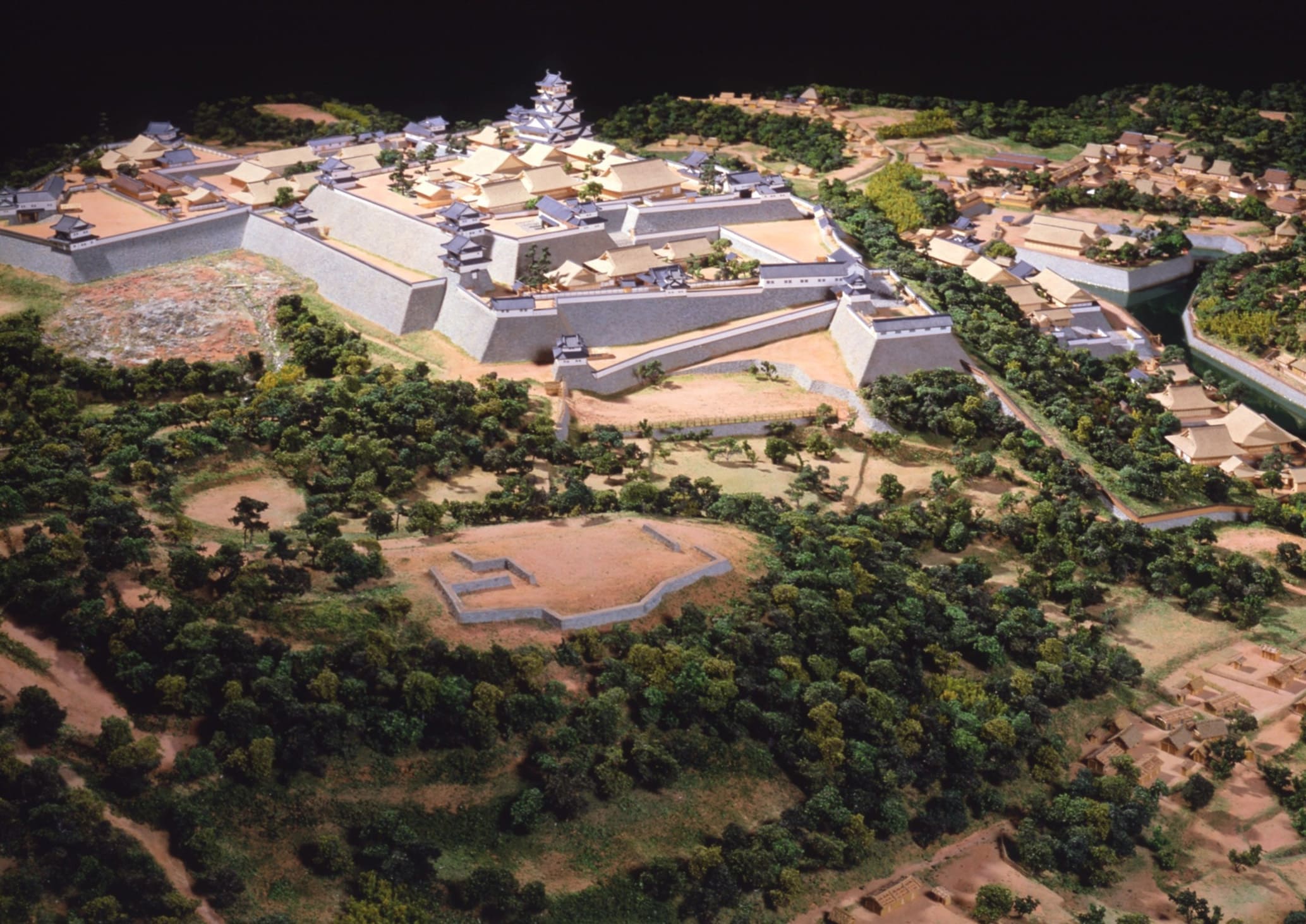 名護屋城とその城下町を南東側から俯瞰した復元模型。天守を中心に城郭、周囲の大名陣屋、城下の居住区や道路配置までが立体的に再現され、戦時に形成された巨大拠点の広がりが分かる。